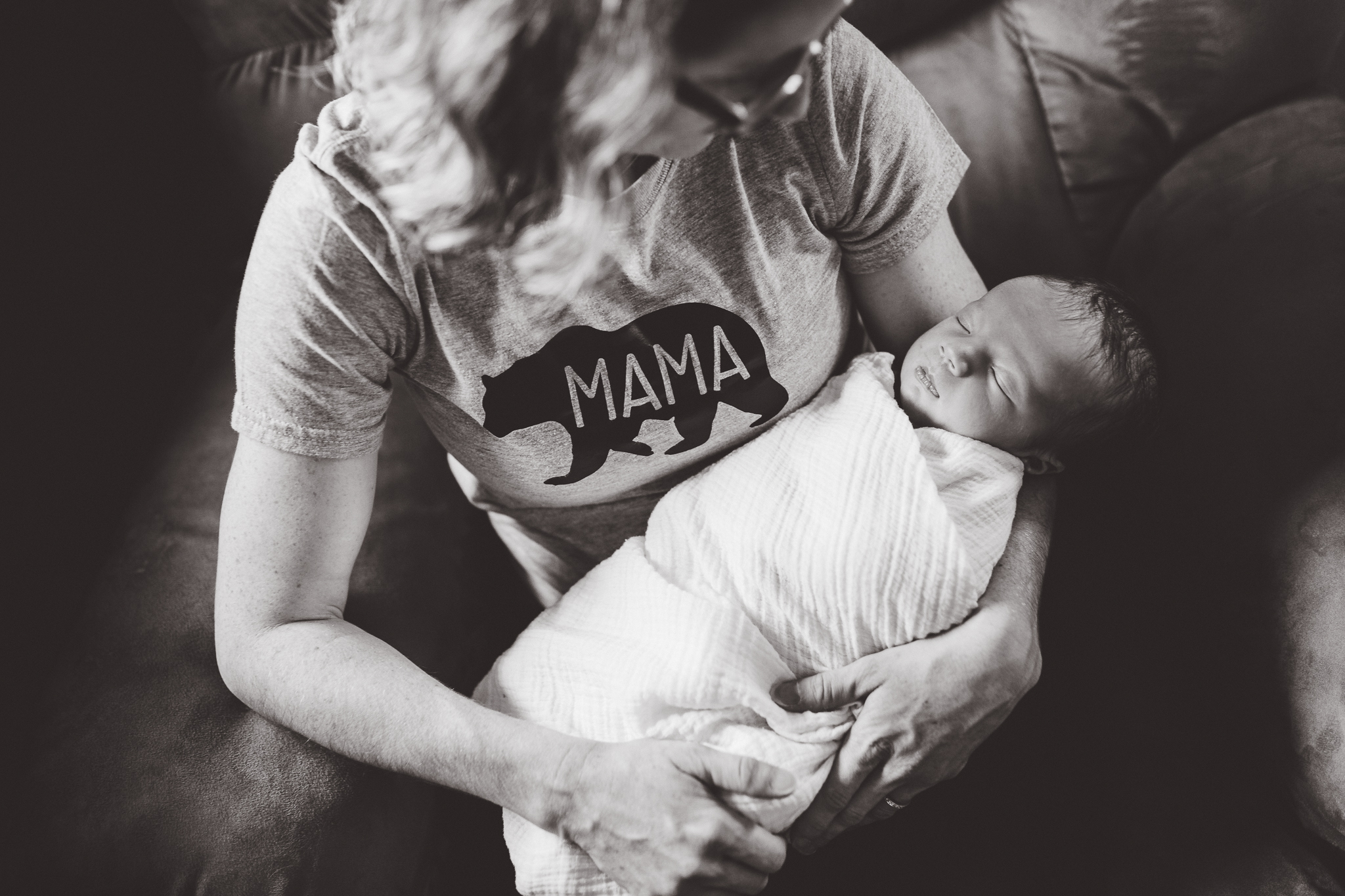 Mother wearing mama bear shirt as she holds her new daughter.