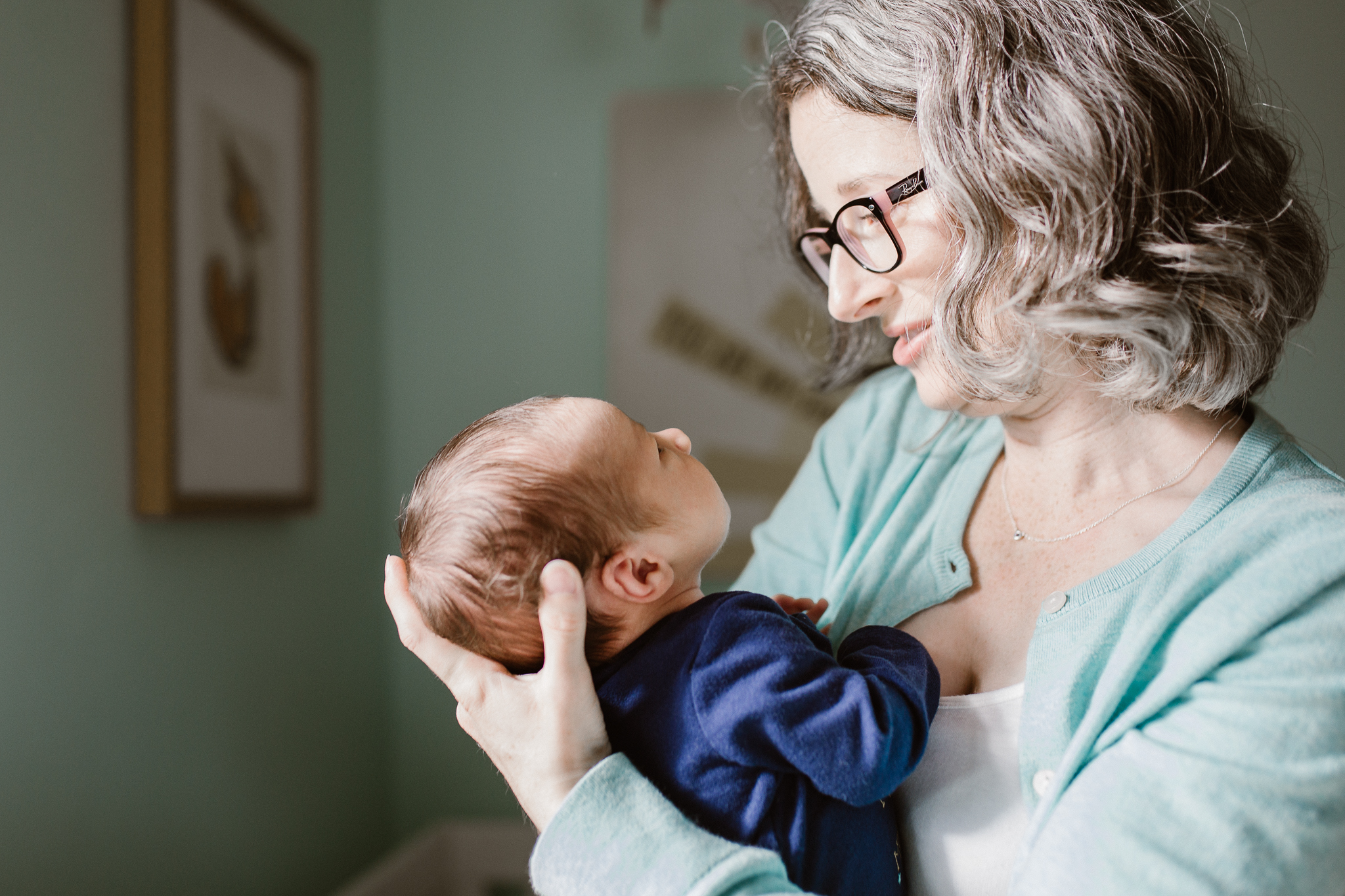 Mother lovingly looking at her newborn baby in her arms.