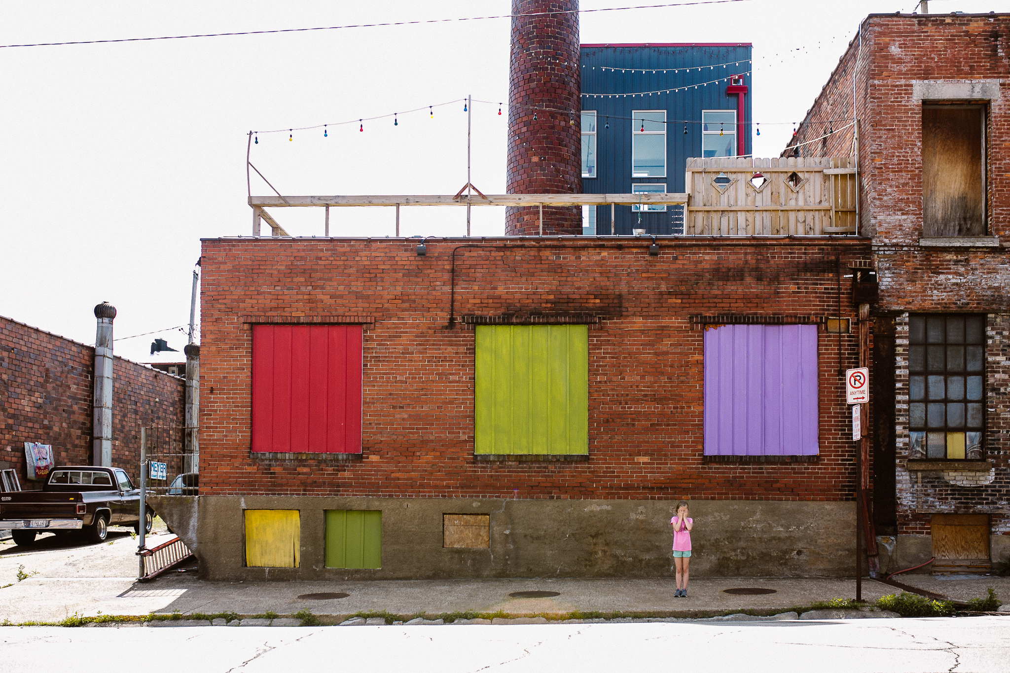 Girl standing in front of an old, funky colored building in Dubuque, Iowa.