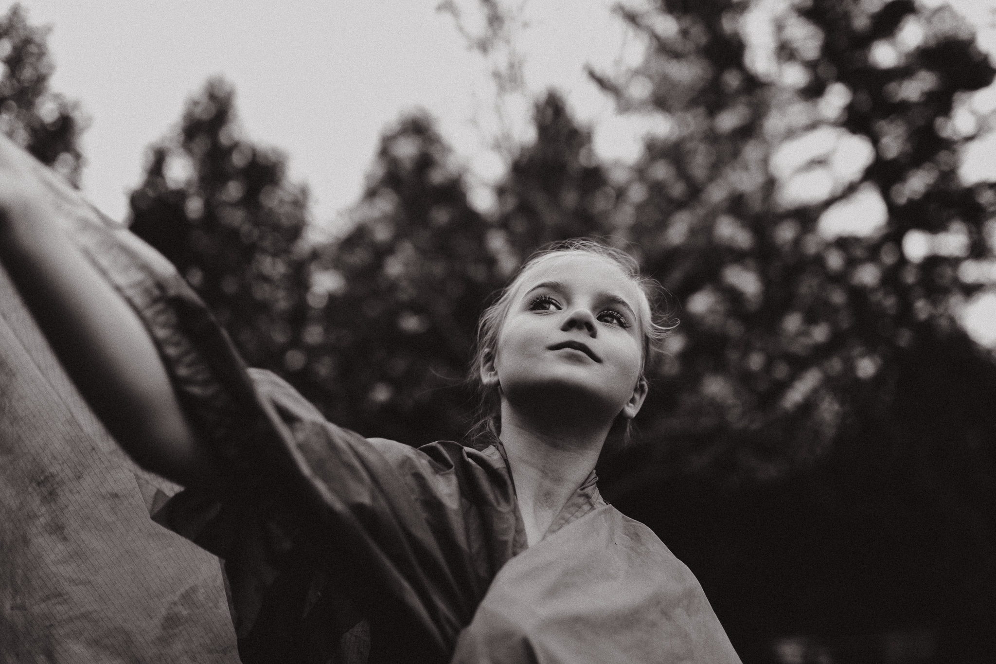 Portrait of a young girl flying a cape outside.