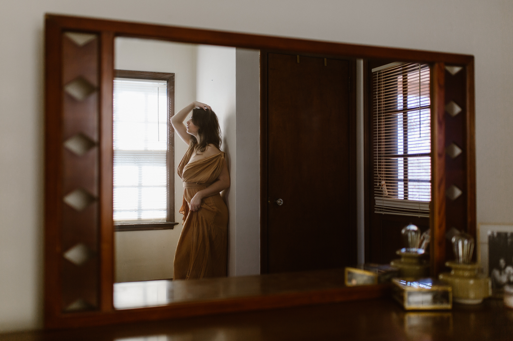 Intimate mirror reflection of a woman in a flowing yellow dress.
